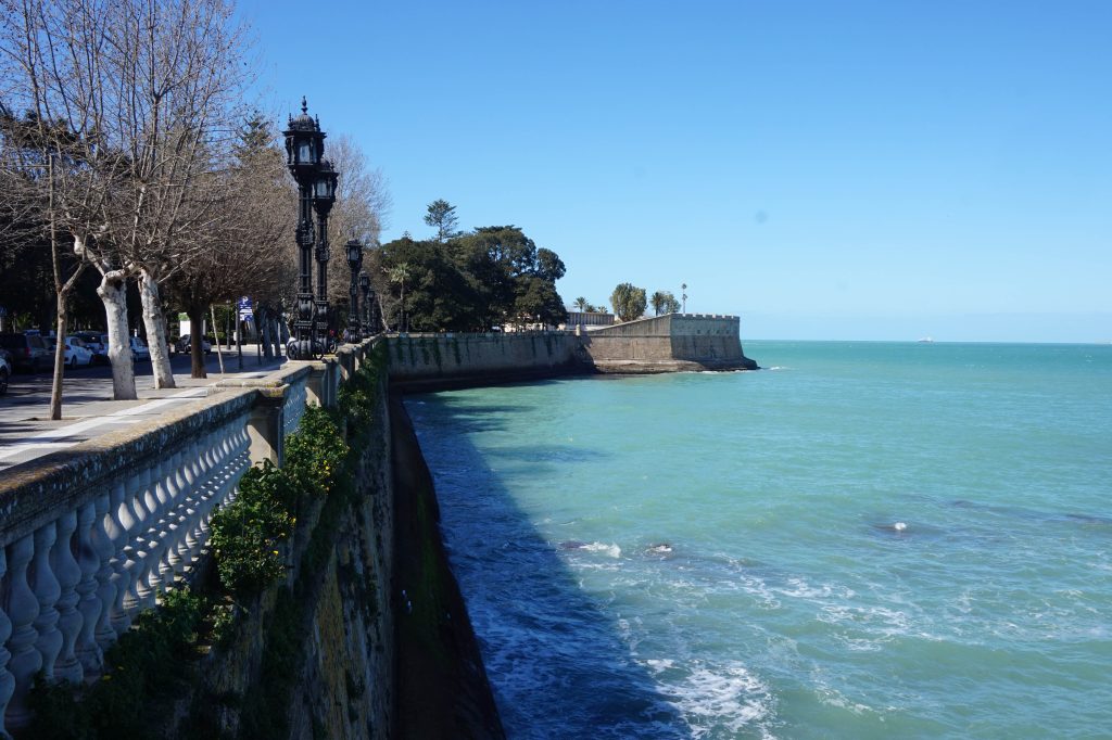 Spacer wzdłuż turkusowego oceanu na promenadzie w Cadiz