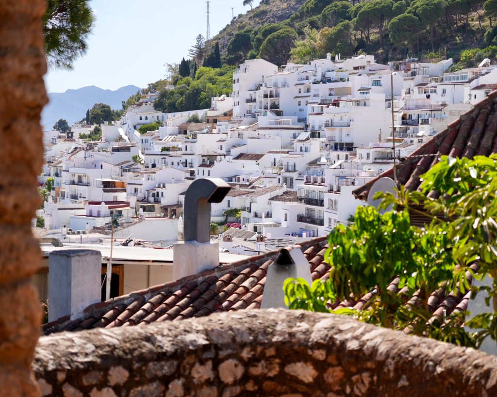 Malownicze białe domy piętrzone na wzgórzu w słonecznej Mijas