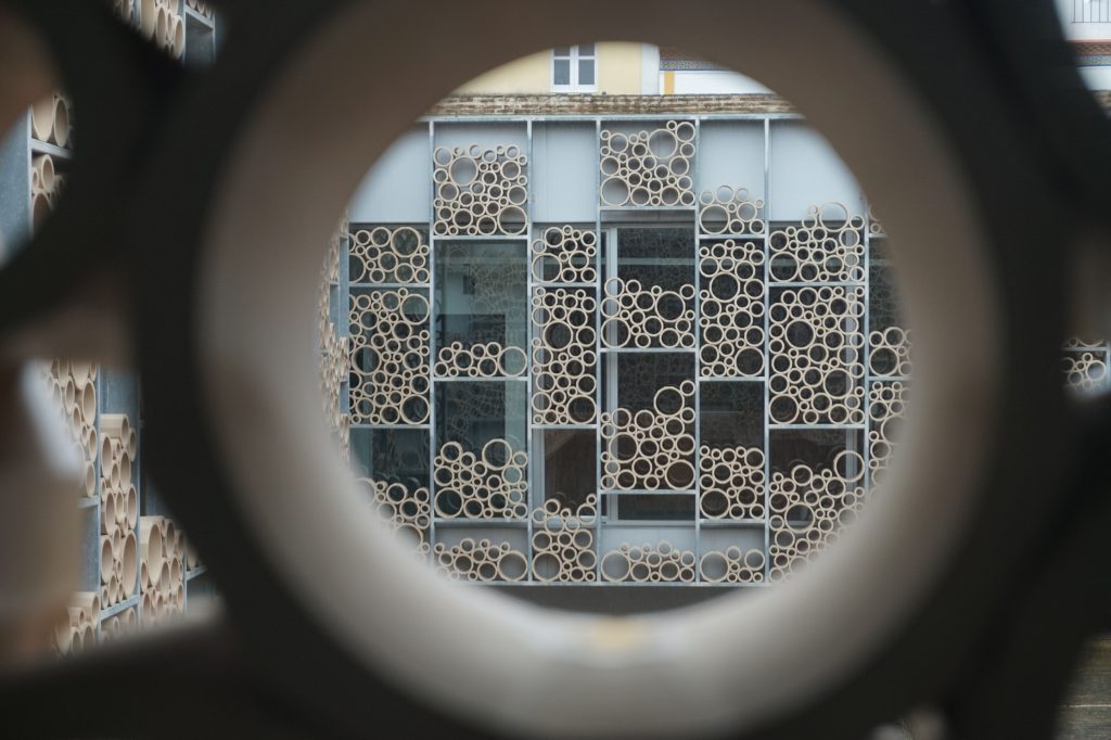 Geometryczne wzory na fasadzie budynku w Sewilli przez okrągły wizjer